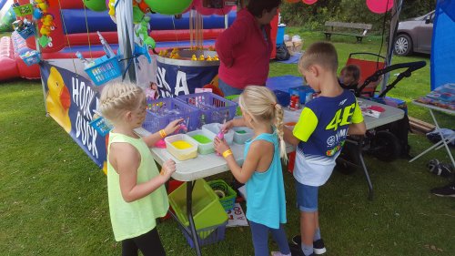three young children exploring the craft making options at the village fun day