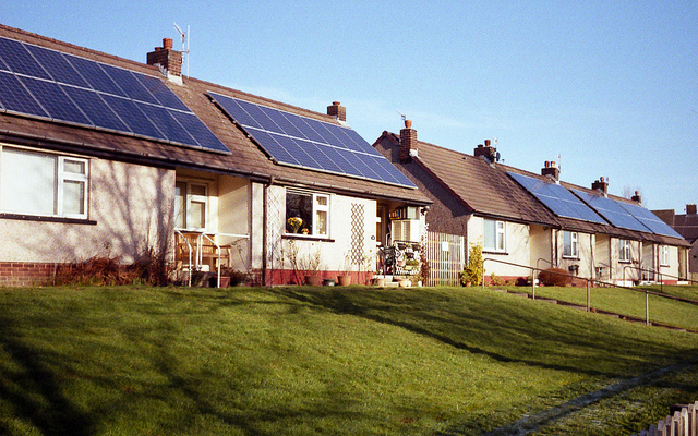 A row of houses with solar panels on their roofs