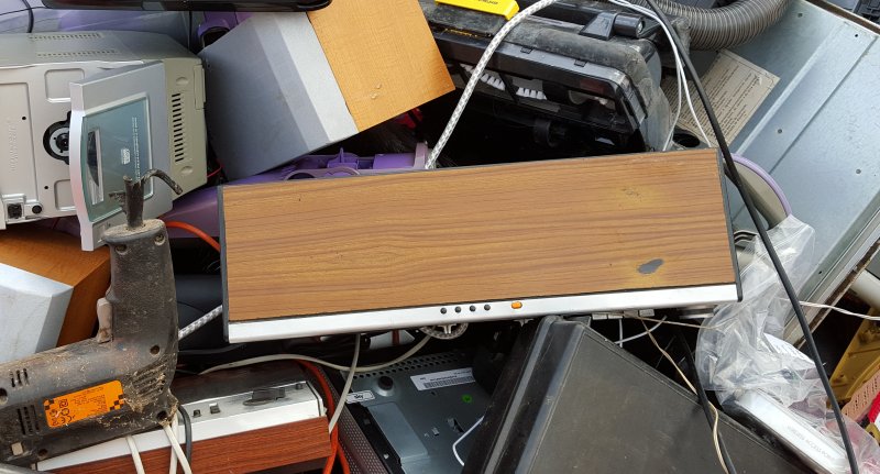 A jumble of abandoned appliances in a skip. The radio is in the middle.
