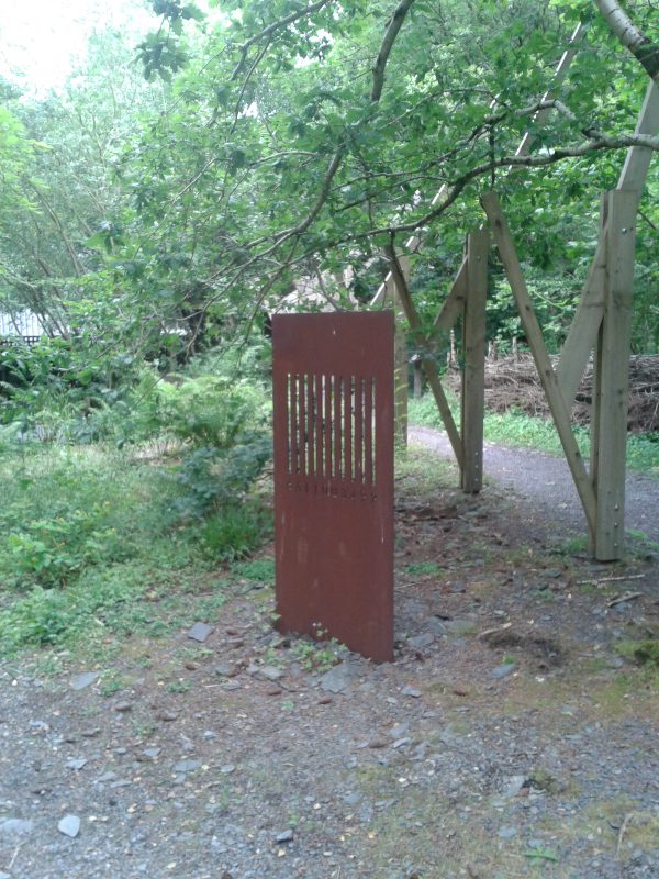 A sculpture: a sheet of steel, roughly the size of a door, with a bar code cut into it, complete with numbers along the bottom.