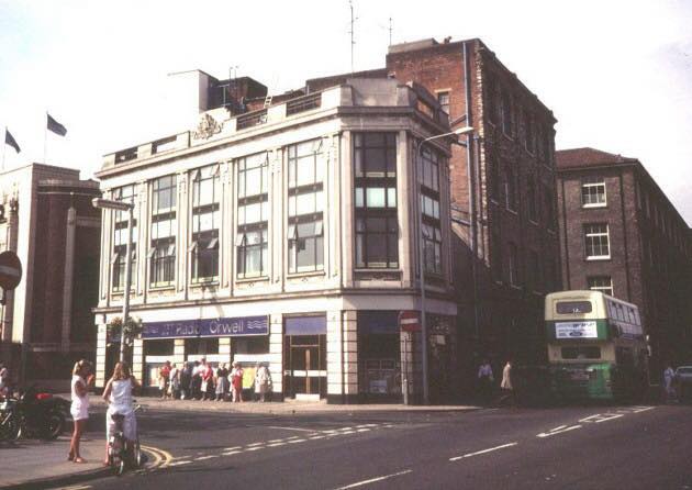 Electric House, Ipswich, before Tower Ramparts Shopping Centre was built. A green double decker bus is stopped outside the back door. The words Radio Orwell are embalzoned across the shop front